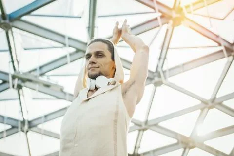 Close up of athletic man practicing yoga in modern park under the glass dome. Stock Photos