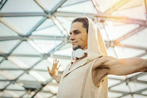 Close up of athletic man practicing yoga in modern park under the glass dome. Stock Photos