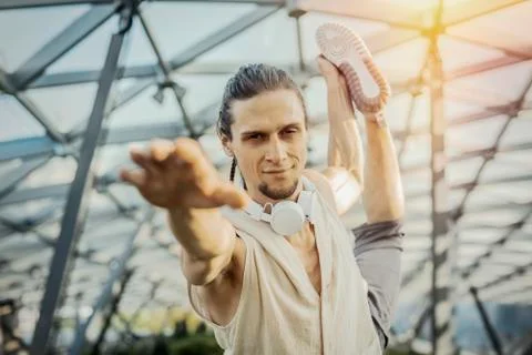 Close up of athletic man practicing yoga in modern park under the glass dome. Stock Photos