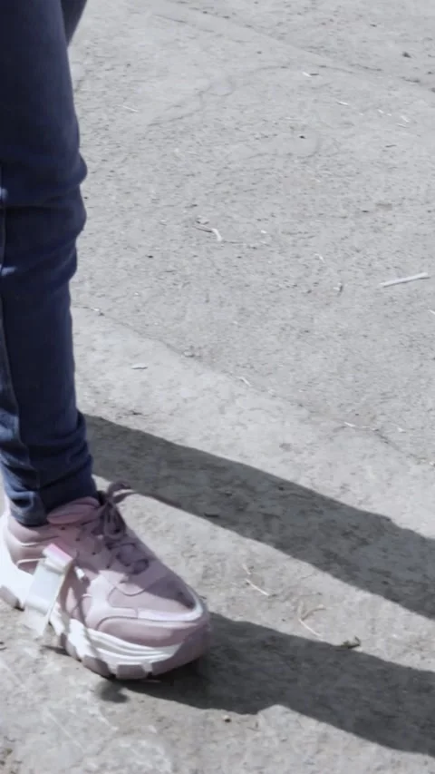 Close-up of athletic shoes walking slowly through the streets of the city. Stock Footage 314912823