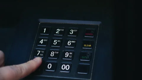 Close-up of ATM keypad as a bank customer enters a PIN code using fingers. The Stock Footage 334713902