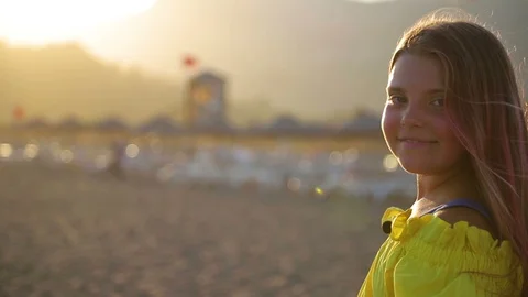 Close up of attractive and confident young girl standing on beach looking out Stock Footage 128599103