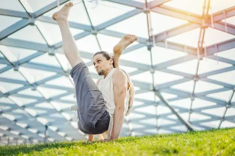Close up of attractive athletic man practicing yoga and warming up outdoors. Foto stock