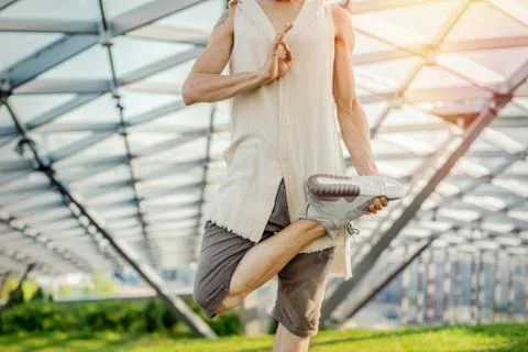 Close up of attractive athletic man practicing yoga and meditating outdoors. Stock Photos