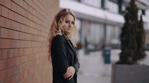 The close-up of an attractive blonde with voluminous curls, shrill makeup looks Video stock 157690543