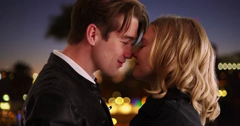 Close up of attractive couple being affectionate and kissing outside at night Vidéo 77222609