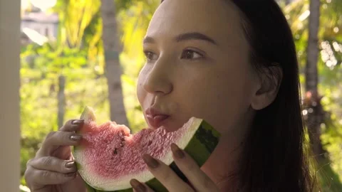 Close-up of an attractive cute brunette young woman eating a watermelon. Vídeo Stock 155962282