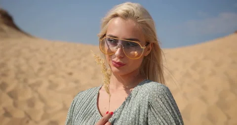 Close-up of an attractive face of a young blonde woman in sunglasses. Girl in Stock Footage 153330760