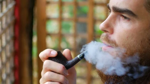 Close up of attractive man with beard smoking on the beach. Outside. Portrait Stock Footage 95907998
