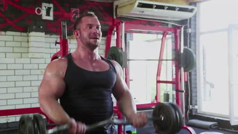Close up of an attractive man bodybuilder performing barbell biceps curls Stock Footage 180136240