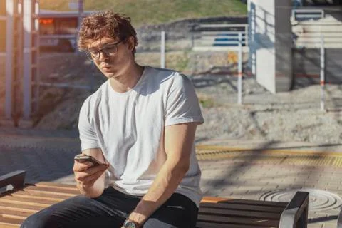 Close up of attractive man looking at mobile phone screen at metro station. Stock Photos