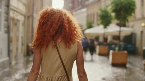 Close up attractive woman with red curly hair walking in the rain on the street Stock Footage