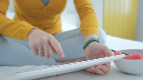 Close up of an attractive woman’s hands using tablet PC scrolling and tapping. 库存影片 94035250