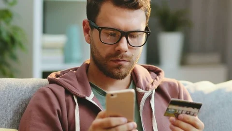 Close up of the attractive young man with a beard in glasses sitting at home Stock Footage 83328214