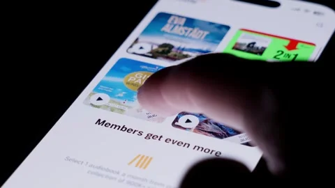 Close-up of the Audible app being opened from a smartphone home screen and Stock Footage 334059932