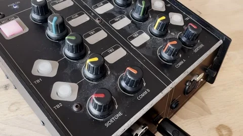 Close-up of an audio mixer control panel with colorful knobs, cue buttons and Stock-Footage 336839925
