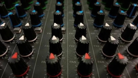 Close-up of an audio mixer with multiple control knobs for sound adjustments. Stock Photos