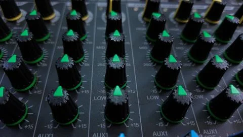 Close-up of an audio mixer with multiple control knobs for sound adjustments. Stock Photos