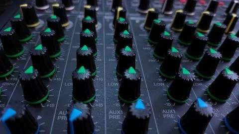 Close-up of an audio mixer with multiple control knobs for sound adjustments. Stock Photos