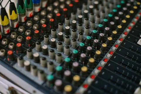 Close-up of an audio mixer with multiple knobs, sliders, and buttons, Stock Photos