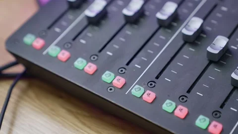 Close-up of an audio mixing console with sliders and illuminated buttons.podcast Stock Footage 298175829