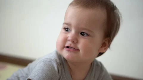 Close up authentic cute infant chubby child girl with cross on chest smiles and Stock Footage 152796364