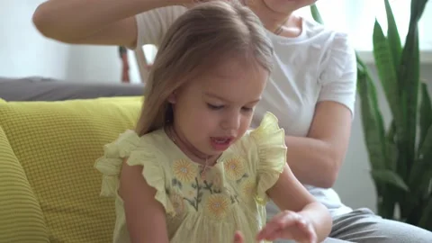 Close up authentic cute young caucasian woman mom caring for child braids Video stock 150237489