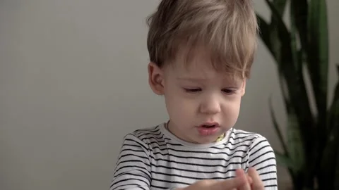 Close up authentic minor preschool boy kid look at camera ponders and points Video stock 149998349