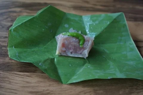 Close up of an authentic Thai Naem Moo or fermented pork sausage wrapped in.. Foto stock