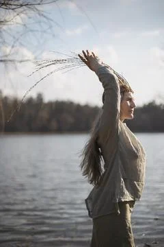 Close up authentic woman posing in front of lake in pagan outfit portrait pic Foto stock