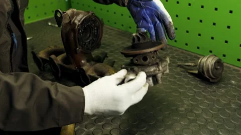 Close up auto mechanic hands in gloves repairing car turbocharger the process of Stock Footage 281582393