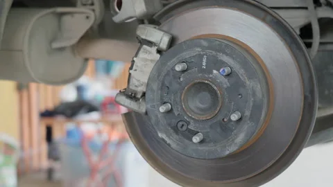 Close up of a auto mechanic's hands putting the break shoes back on Stock Footage 239742945