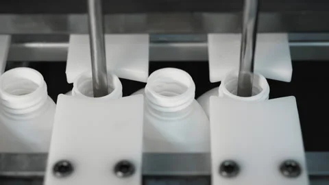 Close up of automatic filling of bottles with shampoo, shower gel, liquid soap. Video stock 283428505