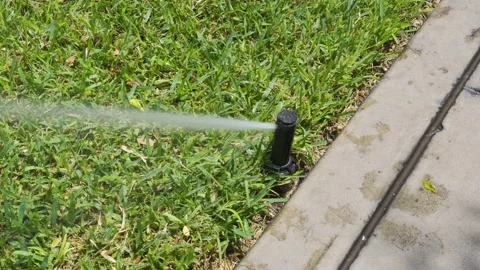 Close-up of an automatic lawn sprinkler moving in a park on the street Video stock 150302135
