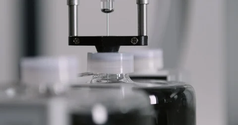 Close-up of automatic syringe taking samples from different bottles Stock Footage 104820872