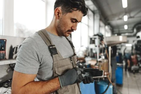 Close up of automechanic using cellphone at workplace in car service Stock Photos