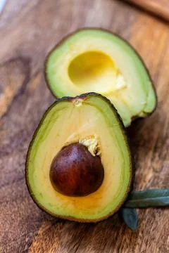 Close-up of an avocado split with the stone, vertical photo Stock Photos