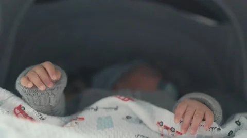 Close up of babies hands while he is sleeping in stroller Stock Footage 193985561