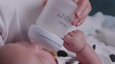 Close-up of Baby Being Fed with Bottle by Parent, Soft Focus Vidéo 336559632