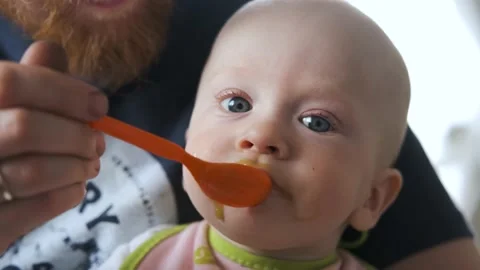 Close-up of a baby being spoon-fed puree Stock Footage 145336090
