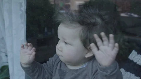 Close-up of baby with both hands on window Stock Footage 301923665