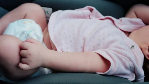 Close up of a baby legs and tiny hands while sitting in a stroller Video stock 316693752