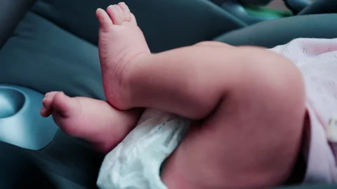 Close up of a baby legs and tiny hands while sitting in a stroller Video stock 316694419