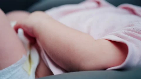 Close up of a baby legs and tiny hands while sitting in a stroller Video stock 316695024