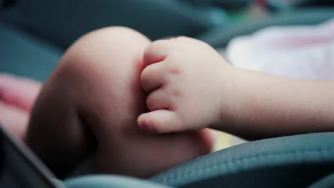 Close up of a baby legs and tiny hands while sitting in a stroller Video stock 316757486