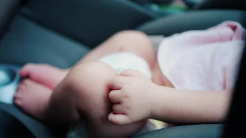 Close up of a baby legs and tiny hands while sitting in a stroller Video stock 316792011