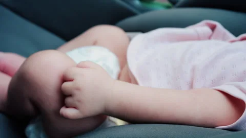 Close up of a baby legs and tiny hands while sitting in a stroller Video stock 316792435