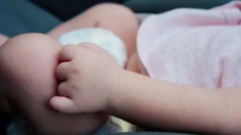 Close up of a baby legs and tiny hands while sitting in a stroller Video stock 316792782