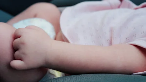 Close up of a baby legs and tiny hands while sitting in a stroller Video stock 316792934