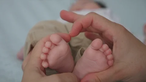 Close-up baby lesg hold in mom's hands Stock Footage